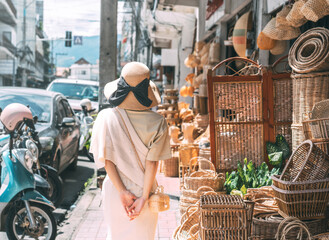 Behind traveler asian woman travel and shopping at wicker souvenir shop at local street Chiang Mai,...