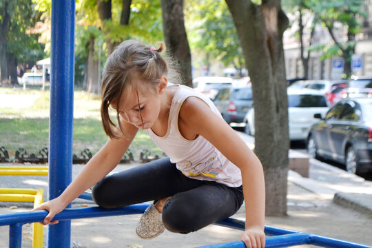 The girl goes in for sports on the Playground on the street. - Powered by Adobe