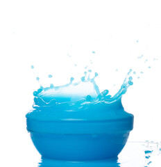 Blue paint water spill splash in bowl cup. Blue liquid lotion moisturizer cosmetic pour float in mid air. Blue cocktail drink explosion throw fluttering. White background isolated high speed shutter