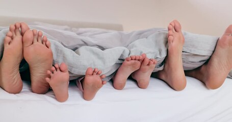 Sleep, feet and family in a bed relax, nap or bonding in their home on vacation, holiday or weekend. Love, toes and children with parents in a bedroom wake up, rest or lazy in a house with security