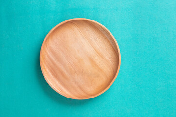 wooden plate on a cyan table