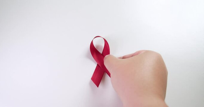 Placing a red ribbon on the center of the frame which signifies the HIV-AIDS worldwide disease awareness and prevention.