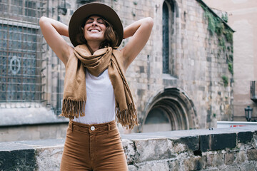 Cheerful woman relaxing while standing near ancient building