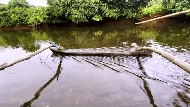 Traditional fishing boat with oars in clear water of Saleri River Goa India 4K