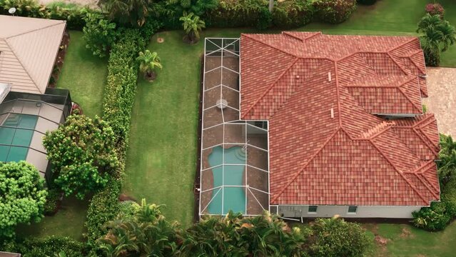 Aerial Above wide view of screened in pool and lanai in florida house. Top down move shot
