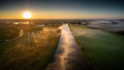 rzeka lub kanał z porannymi mgłami widziane z powietrza