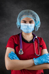 Portrait of female doctor in protective cloth, mask and gloves and stethoscope