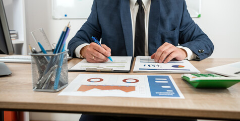 businessman work alone with business document graph and statistic with computer at office.