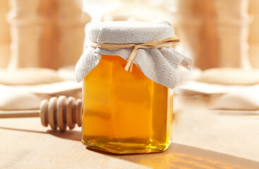 Honey Jar with a wood stick in a blurred background, Healthy Organic Honey, Pure Honey.