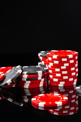 Red and black poker chips on black background