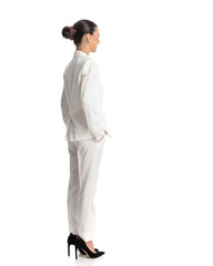 side and back view of elegant woman in white suit holding hands in pockets