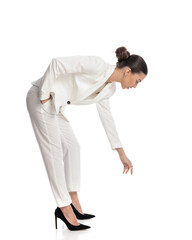 side view of elegant woman looking down, bending to pick up something