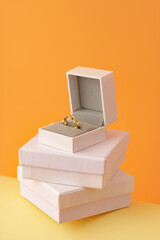 Golden ring in white jewelry box on yellow background