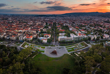 Fototapeta na wymiar Budapest, Hungary - Aerial panoramic view of the Museum of Ethnography at City Park with the skyline of Budapest at background and colorful sunset over the capital of Hungary