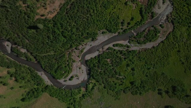 Aerial cinematic drone summer high altitude dirt road Silverton Mountain Ski Resort southern Colorado blue sky late morning stunning lush green Rocky Mountains down river looking down forward motion