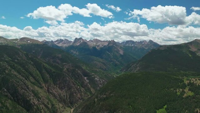 Aerial cinematic drone summer high altitude Molas Pass Silverton Durango southern Colorado late morning stunning lush green blue sky partly cloudy Rocky Mountains circle left movement