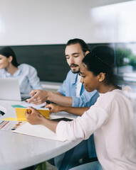 Fototapeta premium Multiethnic coworkers sitting at table n office