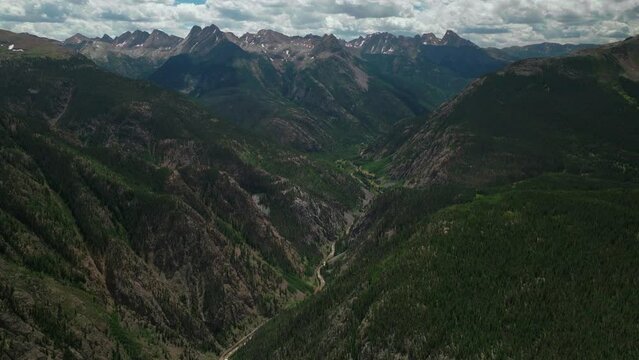 Aerial cinematic drone summer high altitude Molas Pass Silverton Durango southern Colorado late morning stunning lush green blue sky partly cloudy Rocky Mountains 
forward reveal movement