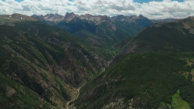 Aerial cinematic drone summer high altitude Molas Pass Silverton Durango southern Colorado late morning stunning lush green blue sky partly cloudy Rocky Mountains reveal forward movement
