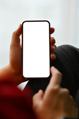 Close up man hands holding smartphone with white screen while relaxing on couch