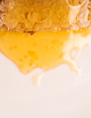 Fresh honeycomb with liquid honey on the white plate. Selective focus.