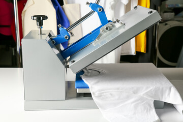 Printing logo. Heat press with t-shirt on white table