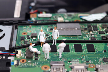 Miniature of a researcher in a notebook. Business concept with Miniature and electronics.
