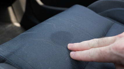 Wet spot on fabric upholstery of car seat.