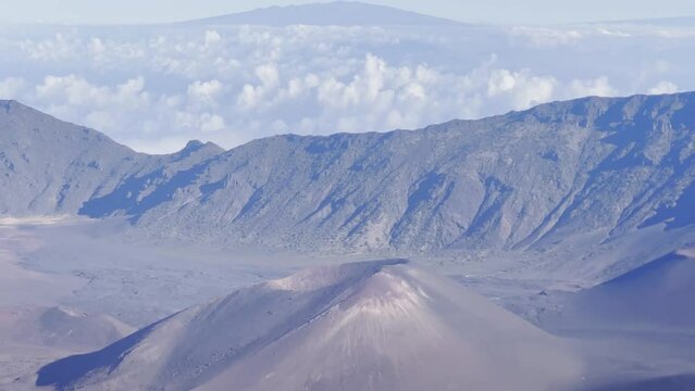 Cinematic booming up shot with foreground elements of the volcanic cinder cone craters at the summit of Haleakala on the island of Maui, Hawai'i. 4K HDR at 30 FPS