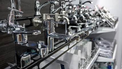 Stainless steel chrome water tap collection in home design store. Plumbing fixture selection for...