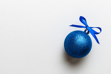 Christmas ball on colored background. decoration bauble with ribbon bow with copy space