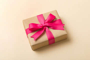 Wrapped christmas or other holiday handmade present in craft paper with colored ribbon. Present...