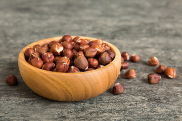 Wooden bowl full of hazelnuts on table background. Healthy eating concept. Super foods