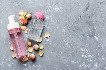 Fancy healthcare bottles for serum, micellar, tonic, toner, lotion, water and cream with rose flower. Natural oranic spa cosmetics concept. Mockup, template, Top view