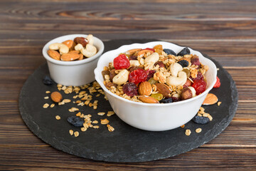 Cooking a wholesome breakfast. Granola with Various dried fruits and nuts in a bowl. The concept of a healthy dessert. Flat lay, top view with copy space