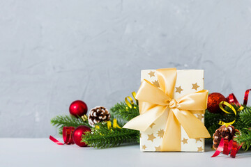 New Year Christmas mood, gift box, branches of a christmas tree, New Year decorations on a colored background