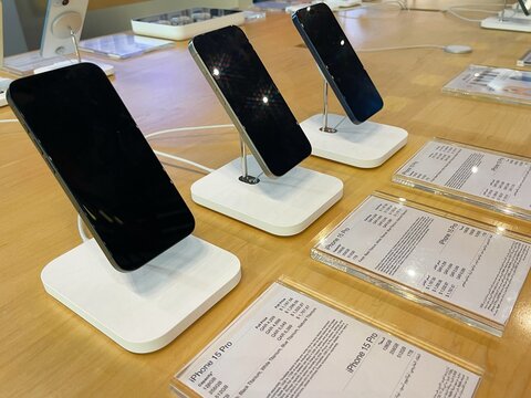 Apple brand store. New smartphones iPhone 15, iPhone 15 Pro Max, iPhone 15 Pro on the table. Latest phone models on counter in a showroom. Demo samples. Plates with prices and features. Official shop.