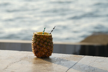 pineapple juice straight from the fruit, on the edge of the ocean. detail.