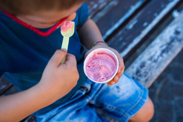 detail of the child eating ice cream. view from above