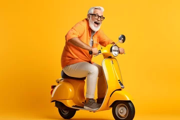 Rolgordijnen happy mature man riding scooter on yellow color background. © Pacharee