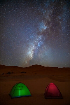 View of camping tents in the Sahara desert at night with the milky way in the sky, Djanet, Algeria, Africa.