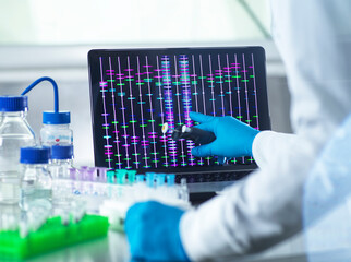 Scientist reviewing DNA information on laptop in laboratory