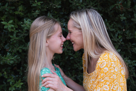 Happy mother and daughter rubbing noses at park