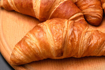 Fresh croissants on a wooden background. French pastries