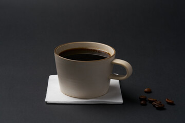 Black coffee and coffee beans on black background