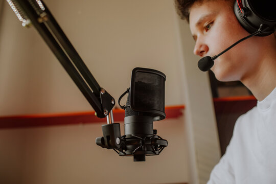 Teenage boy wearing headset and podcasting at home