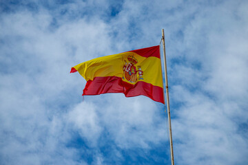 Spanish flag on cloudy sky