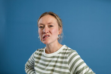 Woman biting lip against blue background