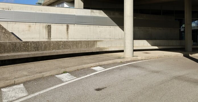 Exit Of A Road Underpass With Large Columns On  Sidewalk And Concrete Block Wall On Behind. Background For Copy Space.