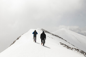 Men hiking with pole on mountain covered in snow